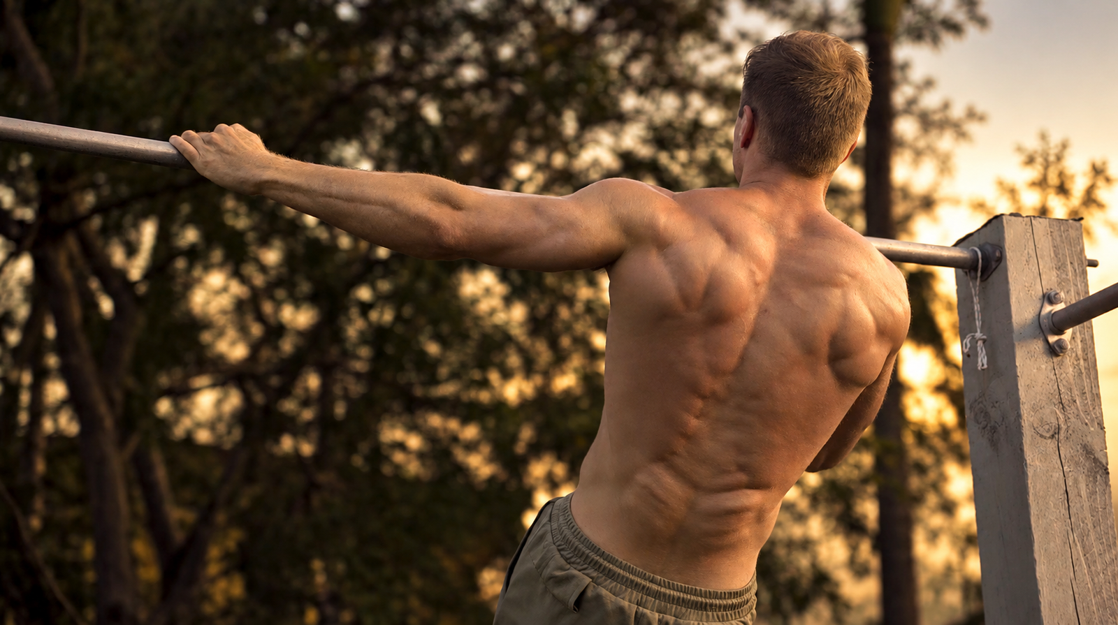 Jake Williams performing an archer pull-up in warm evening light